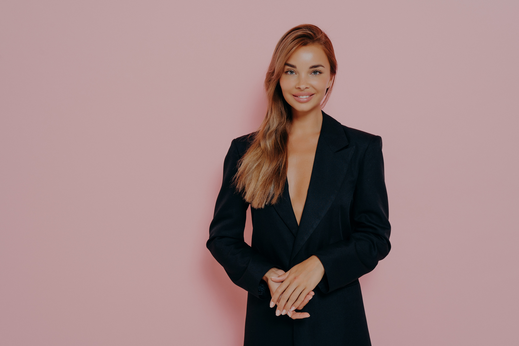 Confident boss lady smiling on pink background